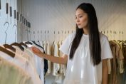 A Woman in White Shirt Choosing from the Wardrobe